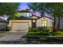 Charming two-story home features a well-manicured lawn, stone accents, and a two-car garage at 2224 Romanum Dr, Winter Garden, FL 34787