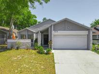 Charming single-story home featuring a well-maintained lawn, inviting entrance, and a two-car garage at 2253 Atrium Cir, Orlando, FL 32808