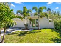 Charming single-story home boasts a well-manicured lawn, palm trees, and a bright green front door at 2411 Center Ave, Orlando, FL 32806