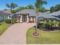 Inviting home with a brick driveway, palm trees and beautiful landscaping at 2480 Northumbria Dr, Sanford, FL 32771