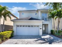 Beautiful two-story home featuring a two-car garage, well-manicured landscaping, and charming architectural details at 321 Pendant Ct, Kissimmee, FL 34747