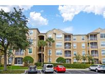 Three-story condo building with manicured landscaping, parking and stairwell to units at 7675 Comrow St # 204, Kissimmee, FL 34747