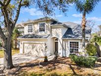 Charming two-story home featuring an attached two-car garage and well-maintained landscaping at 8380 Baywood Vista Dr, Orlando, FL 32810