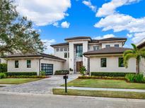 Stunning two-story home boasts a modern design with a paved driveway and lush landscaping at 8521 Lake Nona Shore Dr, Orlando, FL 32827