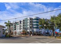 Beautiful condominium building with unique architectural design, balconies, and street-level shops under a sunny sky at 10 N Summerlin Ave # 55, Orlando, FL 32801