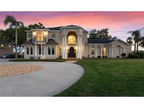 Stunning two-story home with a grand entrance, beautiful columns, and a well-manicured lawn at 10640 Lake Minneola Shrs, Clermont, FL 34711