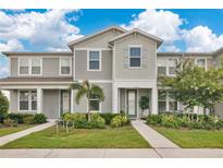 Charming townhome with well-maintained landscaping, complemented by blue skies and curb appeal at 11038 Leafshore Loop, Orlando, FL 32829