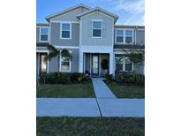 Charming two-story townhome featuring a covered porch and manicured landscaping at 11038 Leafshore Loop, Orlando, FL 32829