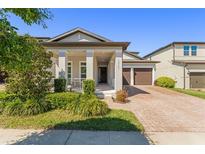 Charming single-Gathering home with a well-manicured lawn and inviting front porch at 14661 Glade Hill Park Way, Winter Garden, FL 34787