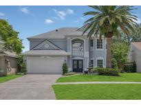 Charming two-story home with a well-manicured lawn, beautiful landscaping, and a large palm tree at 1923 Osman Ave, Orlando, FL 32806
