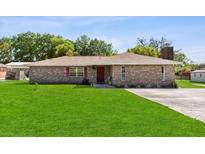 Charming single-story brick home featuring a well-manicured lawn and classic architectural details at 2010 Overlook Dr, Winter Haven, FL 33884