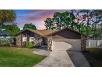 Charming single-story home with stone accents, a two-car garage, and a well-manicured front lawn at 320 Dublin Dr, Lake Mary, FL 32746