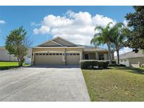 Charming single-story home features a three-car garage, manicured lawn, and mature landscaping at 5832 Tarleton Way, Mount Dora, FL 32757