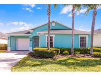 Charming, colorful single-story home with a well-manicured lawn and tropical landscaping at 631 Reserve Dr, Davenport, FL 33896