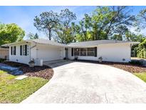 Charming single-story home with a large driveway and well-maintained landscaping in a lush, green setting at 1338 Franklin St, Altamonte Springs, FL 32701