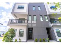 Modern townhome boasts a contemporary design with a gray and white exterior, plus a charming balcony at 135 W Grant St, Orlando, FL 32806