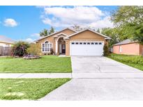 Charming single-story home featuring a well-maintained lawn and a two-car garage in a residential neighborhood at 1562 Woodwind Dr, Apopka, FL 32703