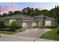 Charming single-story home featuring a brick driveway, two-car garage, manicured landscaping, and a neutral color palette at 1686 Victoria Gardens Dr, Deland, FL 32724