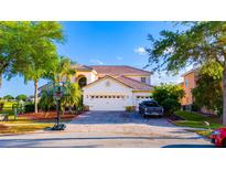 Charming home featuring lush landscaping, three-car garage, and a lovely paved driveway, perfect for families at 2110 Majestic Eagle Pl, Kissimmee, FL 34746
