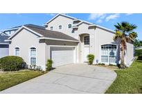 Charming two-story home featuring a well-manicured lawn and a driveway leading to a two-car garage at 218 Castlemain Cir, Davenport, FL 33897
