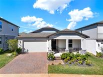 Charming single Gathering home featuring a brick driveway, two-car garage, and a cozy front porch at 2311 Bear Peak Road, Minneola, FL 34715