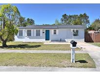 Charming single-story home with well-maintained lawn, light blue exterior, and a vibrant blue front door at 2480 Alamanda Ave, Deltona, FL 32738