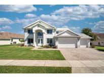 Beautiful two-story home featuring a lush lawn, brick driveway, and three-car garage at 2554 Chapala Dr, Kissimmee, FL 34746