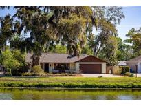 Quaint home nestled among mature trees offering a peaceful curb appeal and a welcoming front porch at 2713 Lime Tree Dr, Edgewater, FL 32141