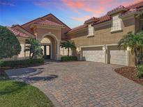 Stunning home with a three-car garage, tile roof and paver driveway with lush landscaping and mature palm trees at 2816 Northampton Ave, Orlando, FL 32828