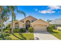 Charming single-story home featuring lush landscaping, a well-manicured lawn, and a two-car garage at 2839 Drifting Lilly Loop, Kissimmee, FL 34747