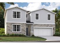 Charming two-story home featuring stone accents, gray siding, attached two-car garage, and well-manicured landscaping at 33448 Seattle Slew Dr, Sorrento, FL 32776