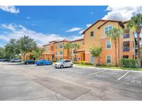 Beautiful two-story condo building featuring a parking lot and lush landscaping at 5471 Vineland Rd # 7108, Orlando, FL 32811