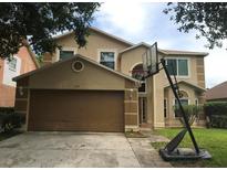 Two-story home featuring an attached garage, neutral stucco exterior, and a basketball hoop in the driveway at 137 Knights Hollow Dr, Apopka, FL 32712