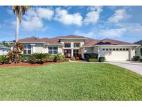 Beautiful single-Gathering home featuring a well-manicured lawn, lovely landscaping, and a two-car garage at 14149 Islamorada Dr, Orlando, FL 32837