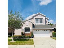 Charming two-story home featuring a well-manicured lawn, inviting curb appeal and a spacious two-car garage at 14339 Windchime Ln, Orlando, FL 32837