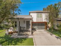 Beautiful modern home featuring a 2-car garage, well-manicured lawn, and a welcoming covered front porch at 1511 E Esther St, Orlando, FL 32806