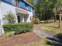 Charming two-story townhome with a landscaped yard and inviting walkway to the front door at 162 Lago Vista Blvd, Casselberry, FL 32707