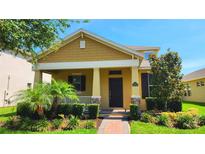 Charming home featuring a cozy front porch, well-manicured lawn, and vibrant landscaping at 16749 Harper Cove Dr, Winter Garden, FL 34787