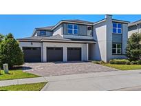 Attractive two-story home featuring a three-car garage and a well-manicured front lawn at 16975 Wingspread Loop, Winter Garden, FL 34787