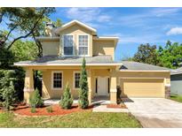 Inviting two-story home with a manicured lawn, attached garage, and a classic stucco facade at 2005 E Grant Ave, Orlando, FL 32806