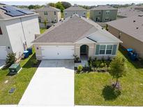 Single-story home with a manicured lawn, showcasing a two-car garage and neat landscaping at 2569 Trinidad Rd, Haines City, FL 33844