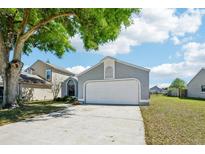 Charming home featuring a two-car garage, mature landscaping, and a well-maintained front yard at 413 Mainsail Ct, Lake Mary, FL 32746