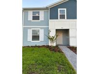 Charming two-story townhome featuring a welcoming front porch and a neatly landscaped yard at 4166 Lana Ave, Davenport, FL 33897