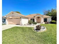 Charming single-story home with a well-manicured lawn and attached two-car garage at 6037 Hickory Grove Ln, Port Orange, FL 32128