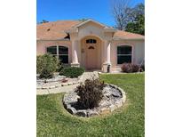 Charming home featuring a manicured front yard and inviting entryway with decorative columns at 6037 Hickory Grove Ln, Port Orange, FL 32128