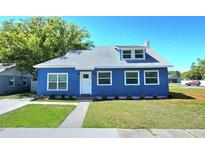 Charming blue home with a well-manicured lawn, showcasing curb appeal at 604 Missouri Ave, St Cloud, FL 34769