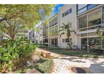 Modern condo building featuring lush landscaping, a tranquil walkway, and plenty of natural light from large windows at 700 Melrose Ave # L-23, Winter Park, FL 32789
