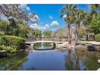 Scenic pond with bridge surrounded by lush greenery and mature trees; community feature at 700 Melrose Ave # L-23, Winter Park, FL 32789