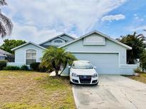 Charming single-Gathering home with a two-car garage, palm tree, and well-manicured front yard at 72 Saint Kitts Cir, Winter Haven, FL 33884