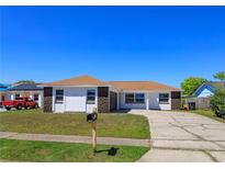 Charming single-story home featuring a well-manicured lawn and a long driveway, perfect for Gathering living at 7717 Boreas Dr, Orlando, FL 32822